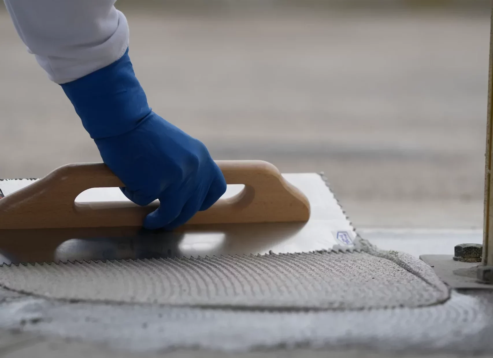 Nella seguente immagine è rappresentato il dettaglio della spatola che stende la resina guidata dalla mano esperta di un dipendente di F-resine. Pavimenti e rivestimenti in resina.